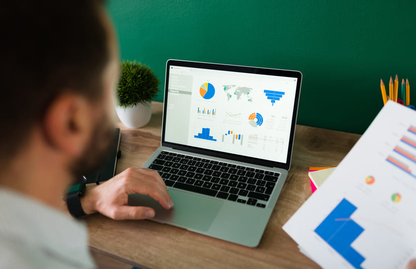 A man doing PPC audit of the campaign using laptop and charts